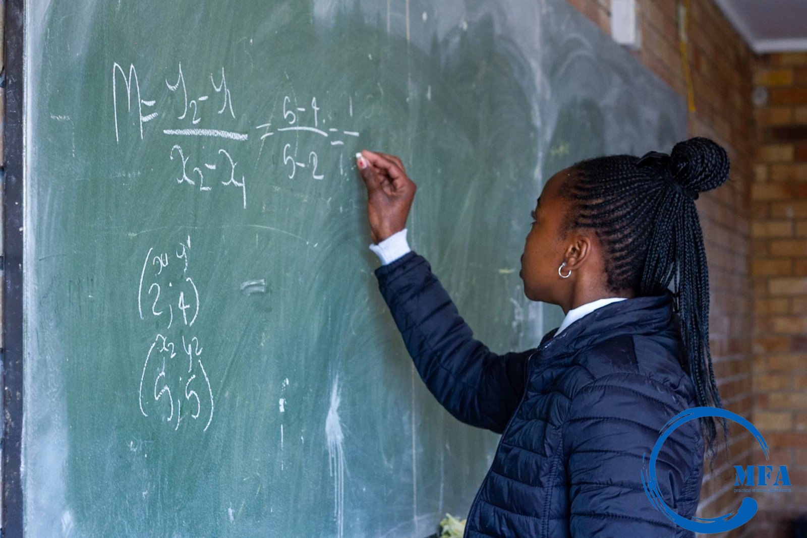 Student solving a maths problem on the chalkboard
